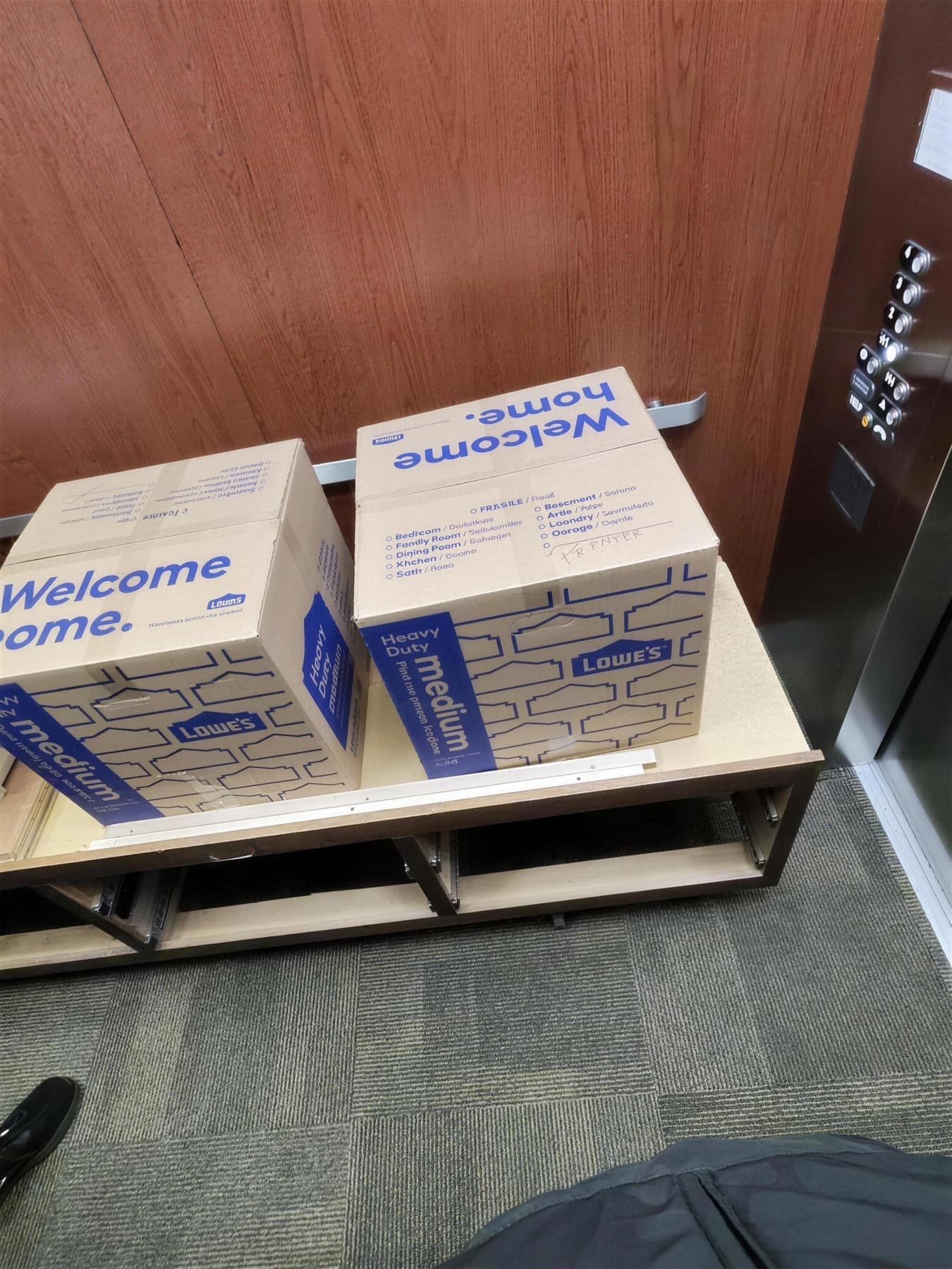 Moving boxes stacked near an elevator lobby ready for delivery