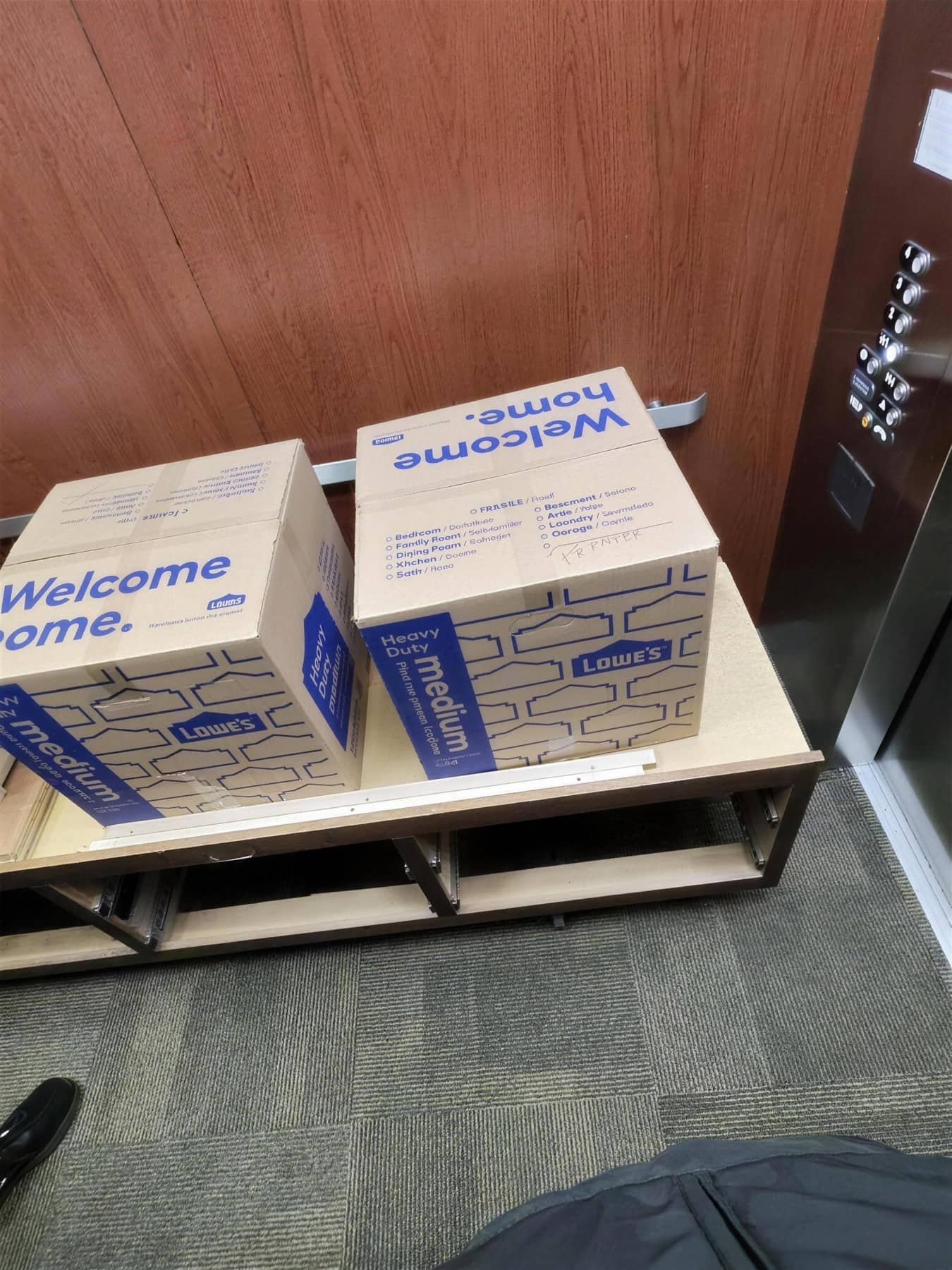 Moving boxes stacked near an elevator lobby ready for delivery