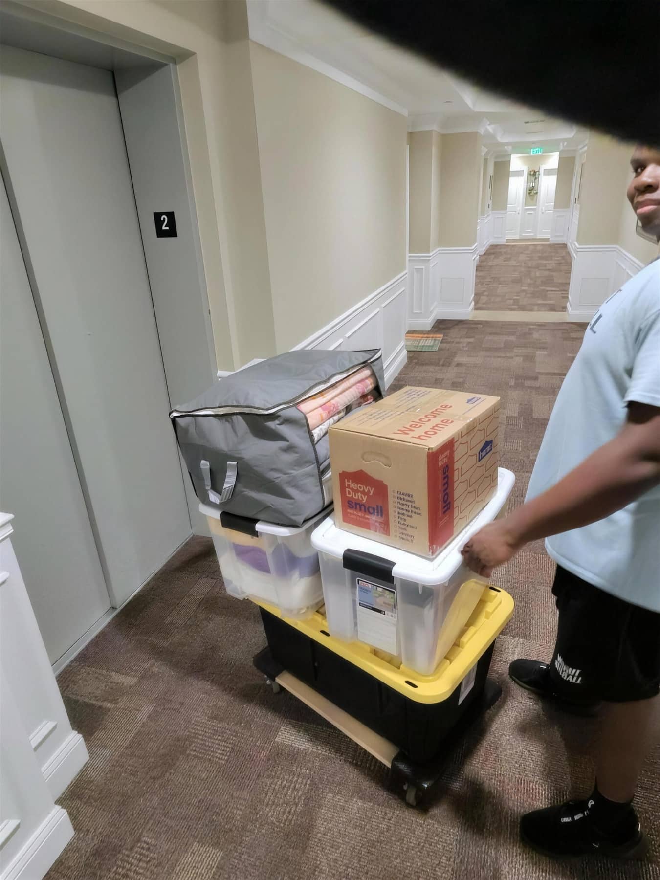 NoTimeMover crew rolling a loaded dolly through an upscale residential hallway