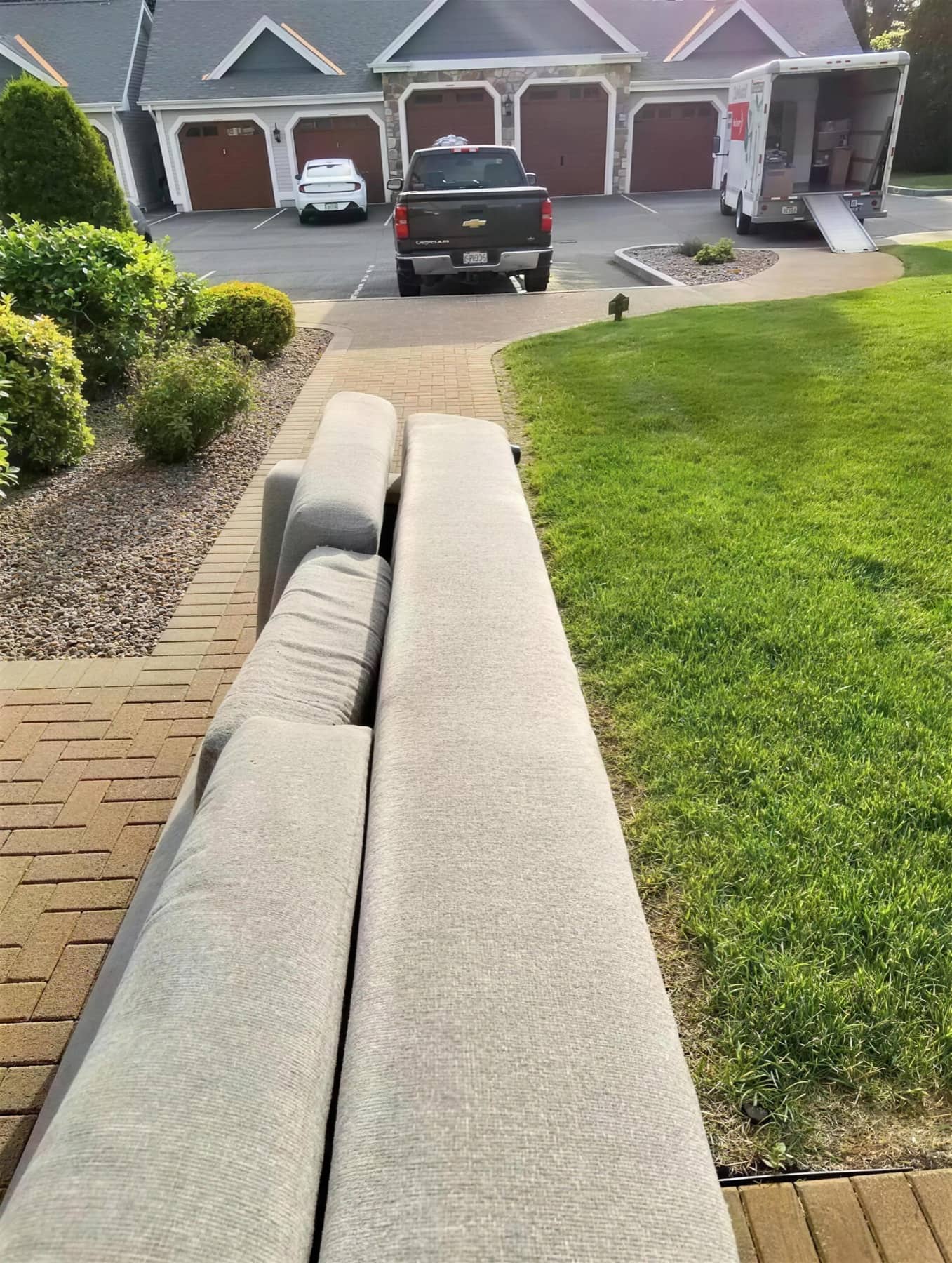 NoTimeMover crew carrying a sectional sofa down a brick-paved driveway